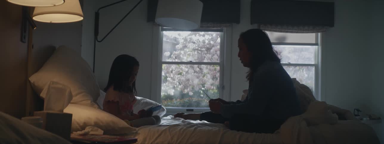 A mother and daughter talking in bed