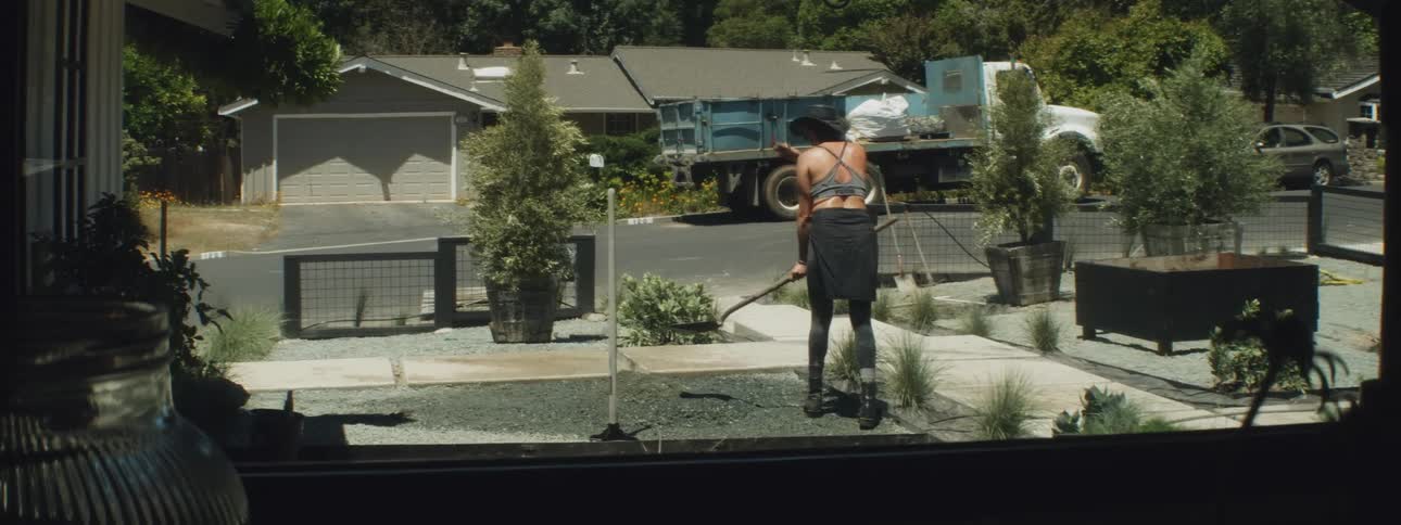 A man and woman do yard work in their backyard