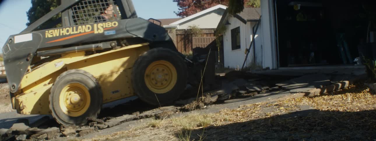 Man operates forklift to tear up driveway