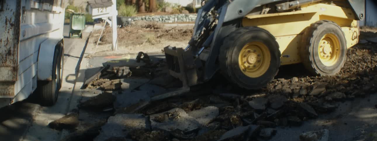 Forklift breaks up driveway between parked trailer and front of house