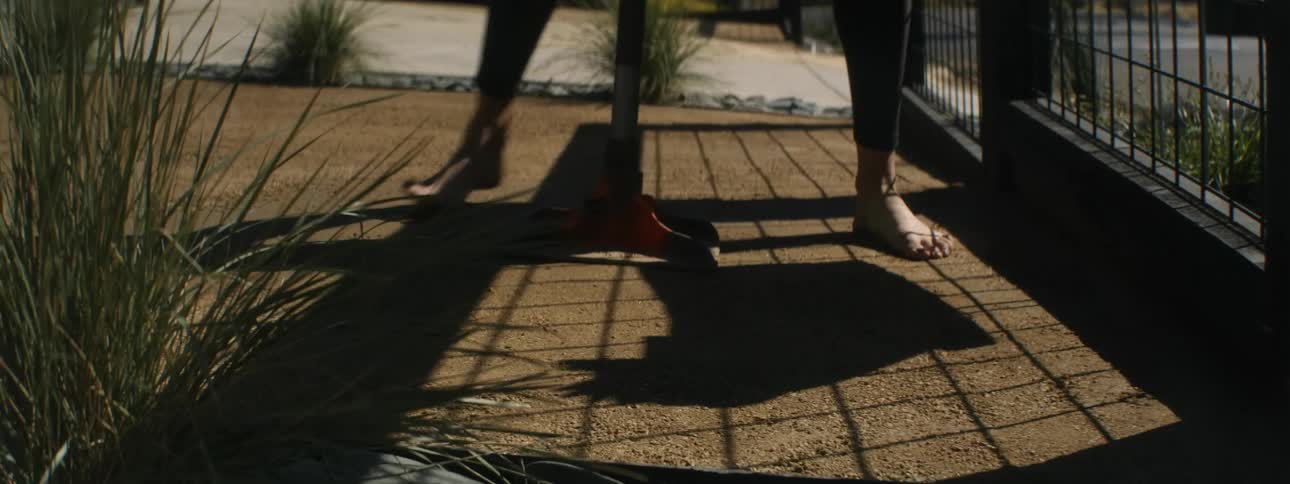 A person is using gardening tools in the yard