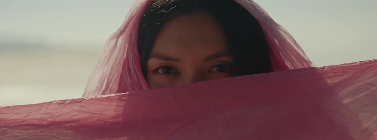 A woman in pink veil hides face
