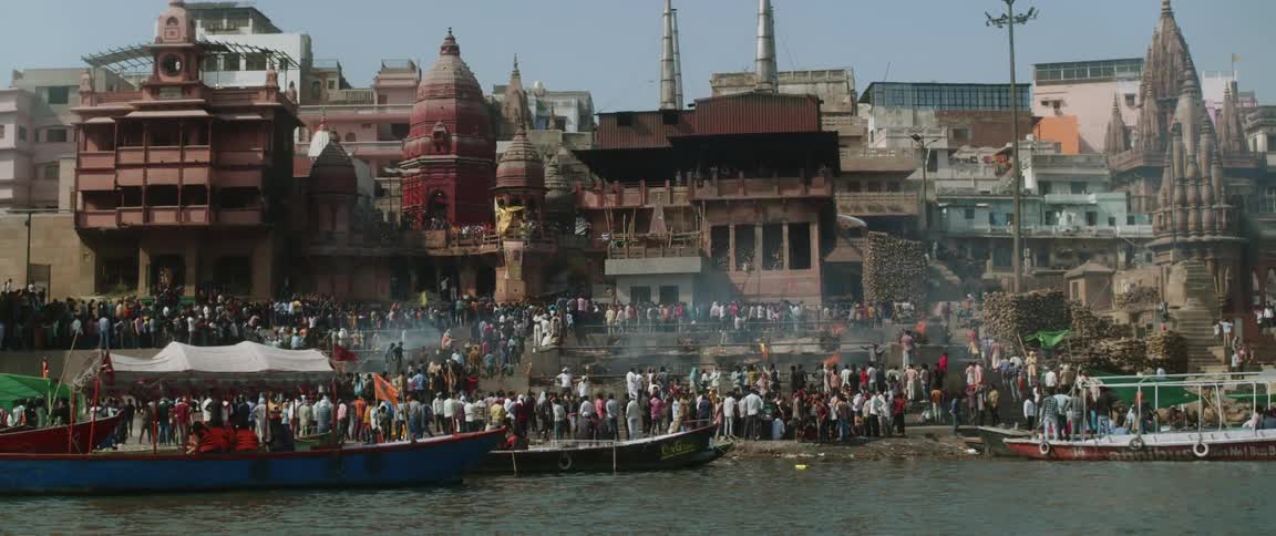 People gathered around a waterfront temple on india