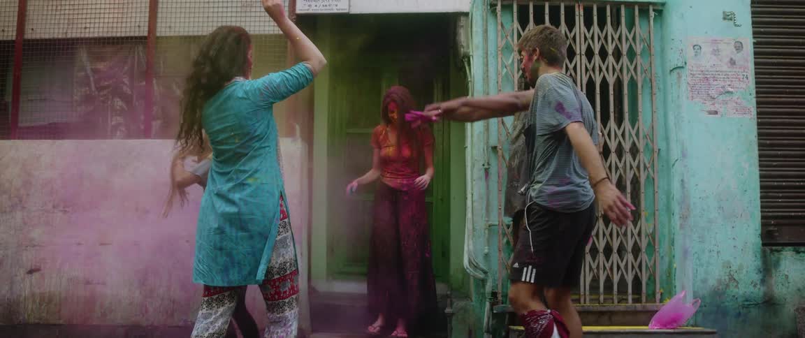 Friends celebrate holi by throwing colored powder at each other