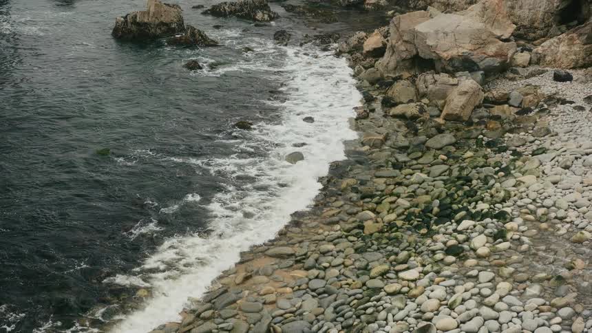 Ocean waves are flowing and breaking on a rocky beach