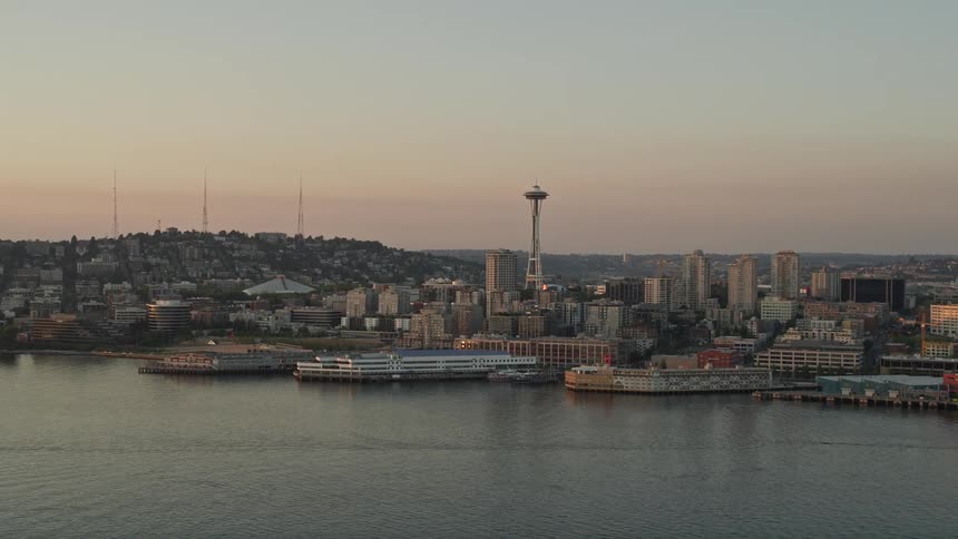 A stunningaerial view of the Seattle Space Needle and Central Waterfront piers at sunset showcasing the iconic landmarks of Downtown Seattle Washington