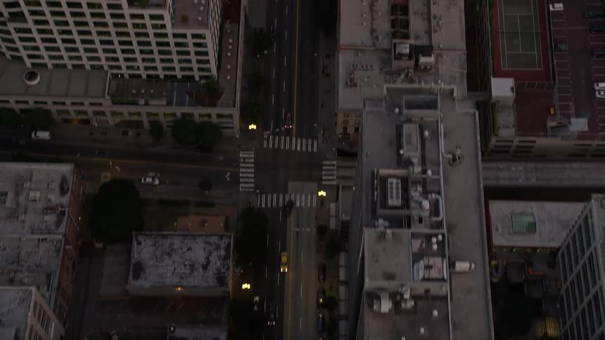 Bird's eye view aerial footage of sunset over downtown Seattle Washington capturing the bustling traffic on city streets between towering buildings
