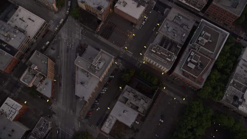 A mesmerizing aerial view of vibrant city streets at sunset in Downtown Seattle Washington as the camera looks straight down on the bustling metropolis