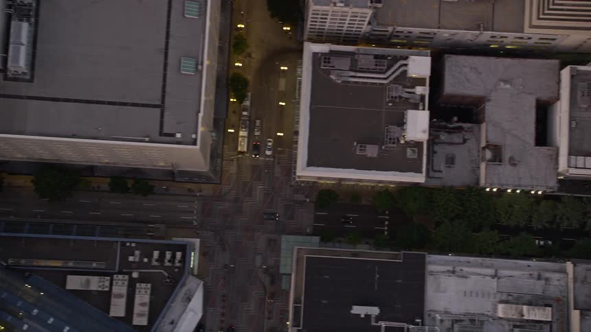 Aerial footage captures the bird's eye view of Downtown Seattle at sunset showcasing the high rise buildings and city streets along 5th Avenue