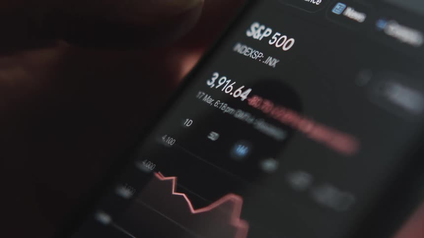 A person is browsing stocks on their cell phone