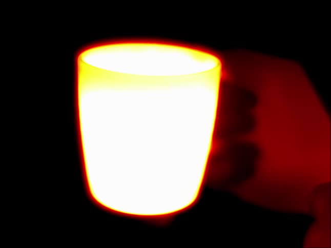 A person is holding a tea mug in infrared imaging