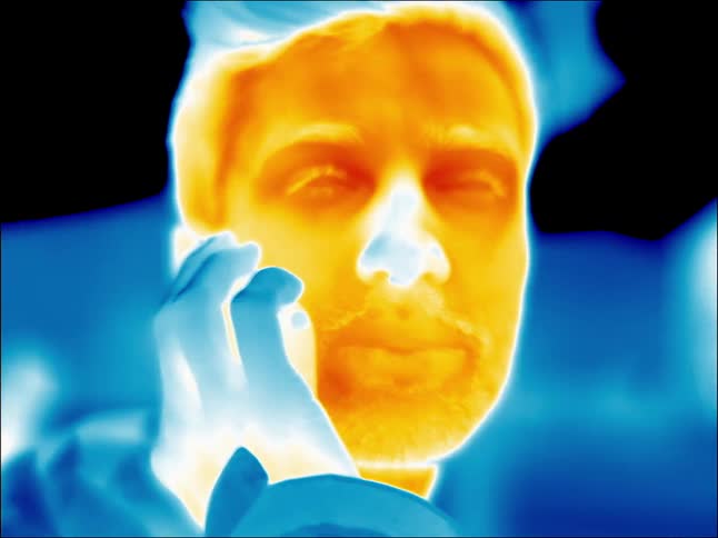 A man is talking on a cell phone outside in infrared