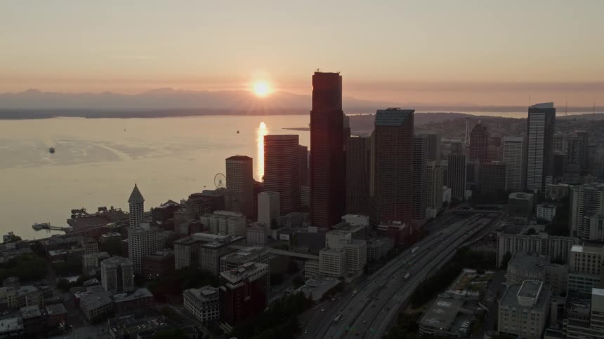an aerial view of downtown Seattle at sunset showcasing the majestic skyscrapers and Elliott Bay in the background