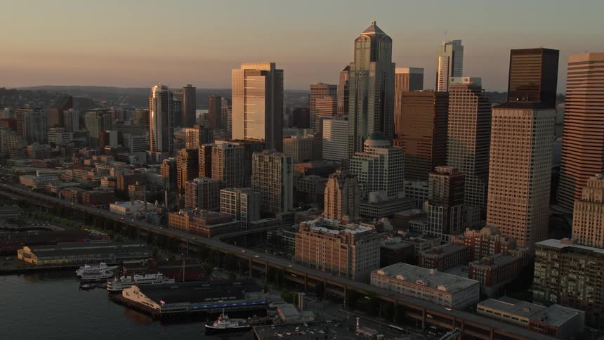 A stunning aerial view of downtown Seattle with its skyscrapers Central Waterfront piers and a beautiful sunset