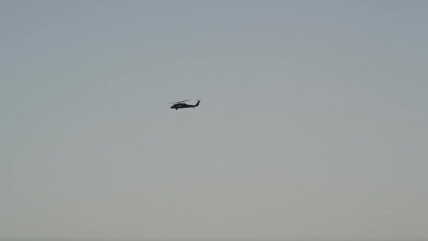 Aerial footage of a Blackhawk helicopter tracking through the clear skies during sunset in Seattle Washington
