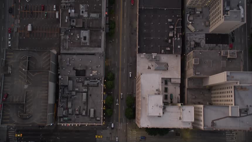 Bird's eye view of sunset over Downtown Seattle as vehicles travel on 3rd Avenue surrounded by high-rise buildings