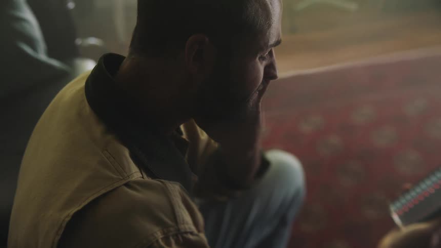 A man touches his head while looking at his phone