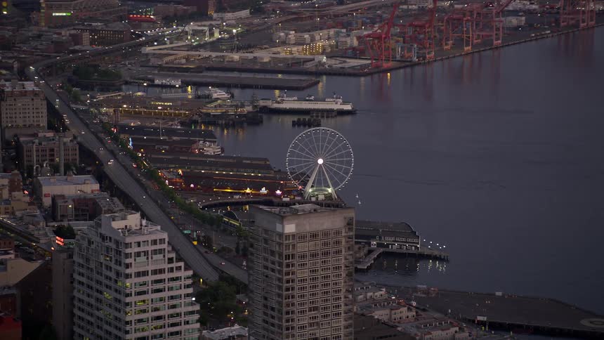An aerial view of the Seattle Great Wheel behind the Seattle Aquarium in Downtown Seattle Washington during sunset
