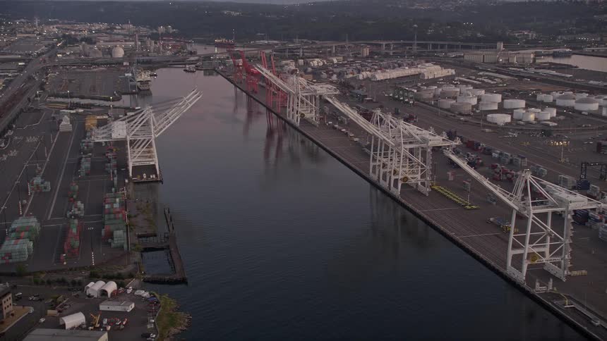 Aerial footage of cargo cranes at sunset by the Duwamish Waterway Harbor Island Seattle Washington showcasing the bustling shipping industry and scenic waterfront industrial area