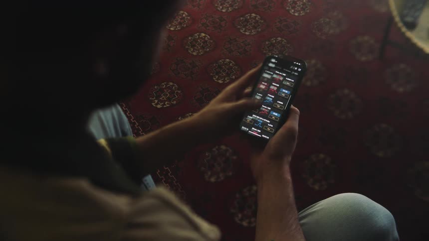 The view is of a boy looking at there phone inside of there home