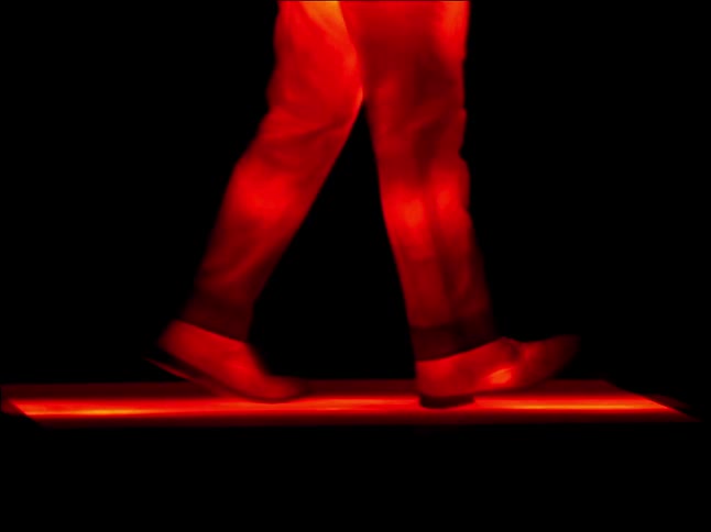 Legs of a man walking on a threadmill walking on a threadmil