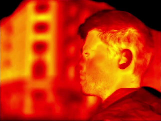 A video of a man walking outdoors with an infrared camera