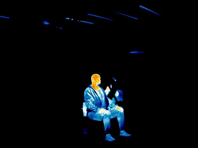 A man laying down in a room in infrared