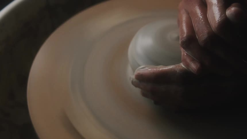 A person is forming clay