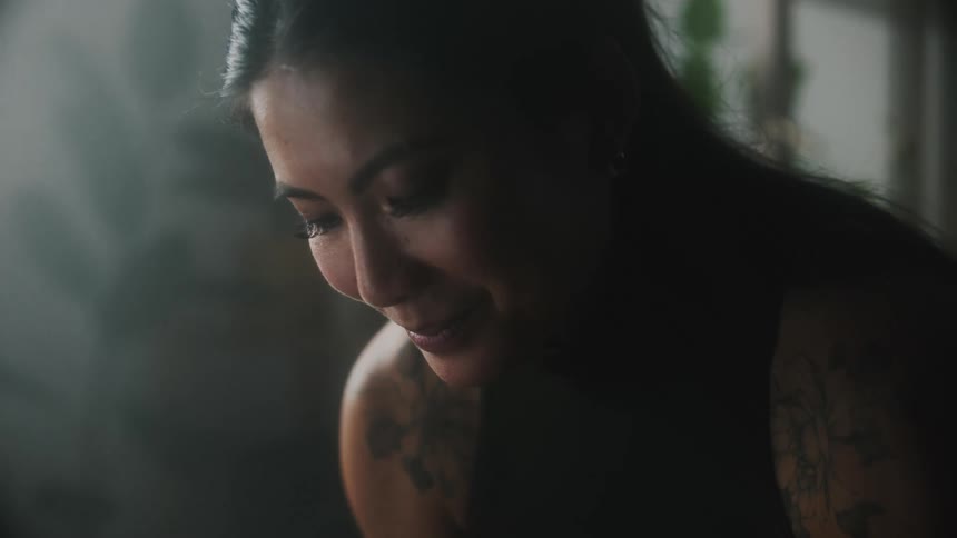 A young woman is smiling inside of her room
