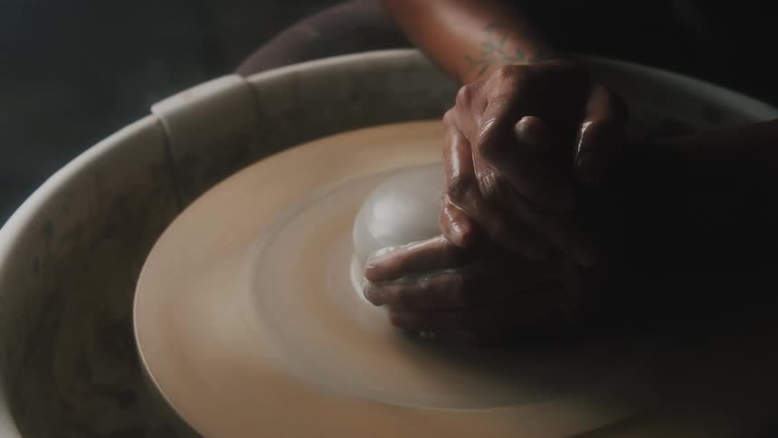 A person working with clay on a wheel