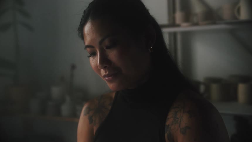 A woman looks down and smiles while pondering what she saw