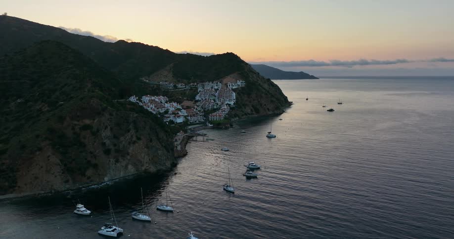 A small town on a coastal cliff surrounded by boats