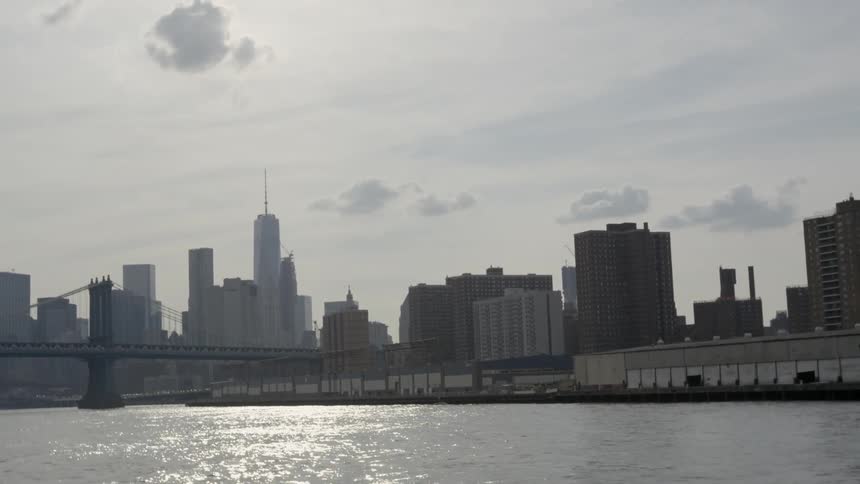 A city is viewed from the rail of a boat
