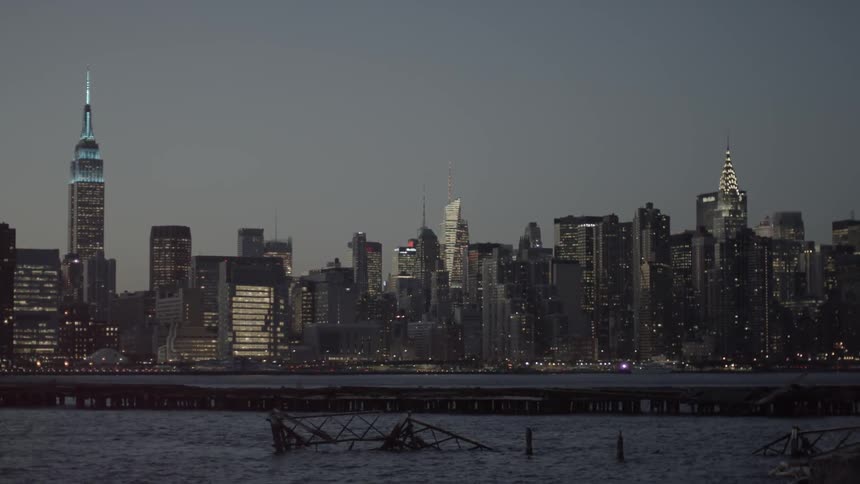 The city across the water is lit at dawn