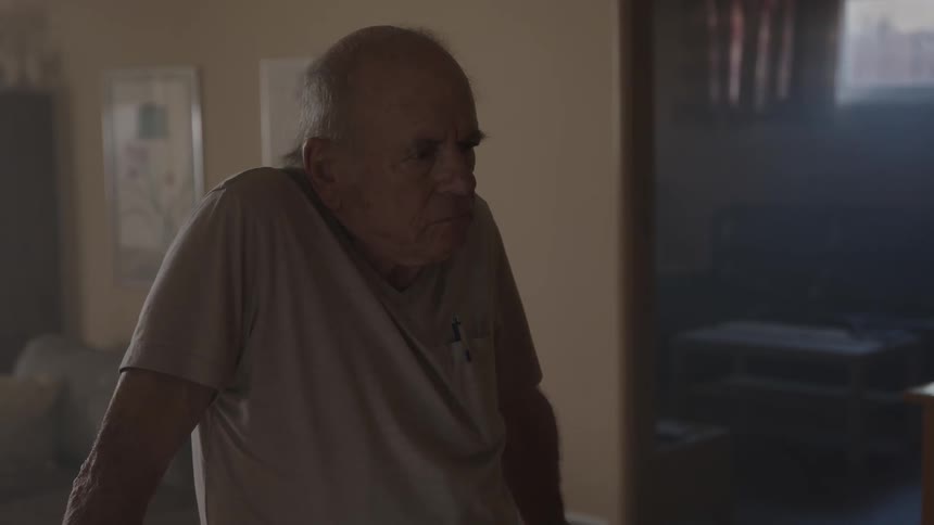 A man appears confused while standing in his house