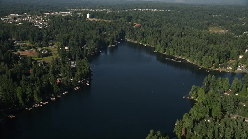 Fly over Pine Lake in Sammamish Washington capturing stunning aerial shots of lakeside homes with docks and breathtaking views of the surrounding nature