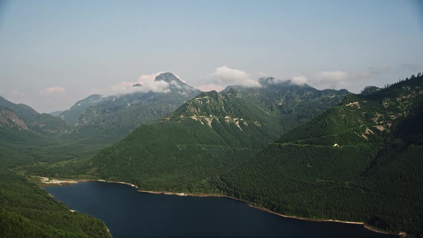 Aerial footage of wooded mountain peaks and shoreline of the South Fork Tolt Reservoir in the Cascade Range Washington