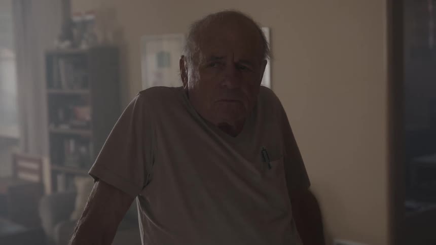 Sad elderly man with white t shirt goes upstairs