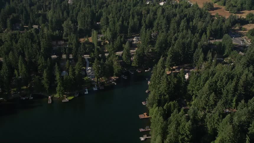 Aerial footage of Pine Lake in Sammamish Washington showcasing lakefront homes with docks on a sunny day