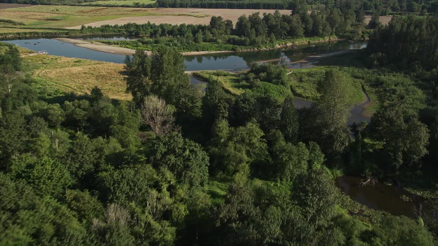 Aerial view of a golf course in Carnation Washington featuring green fields trees and a bend in the river