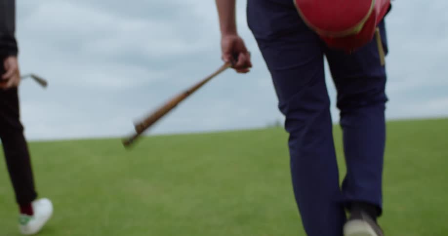 Golfers carry their equipment on the course