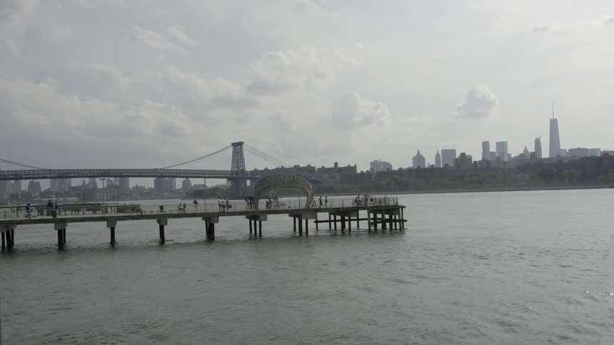 A pier sits with a city in the distance