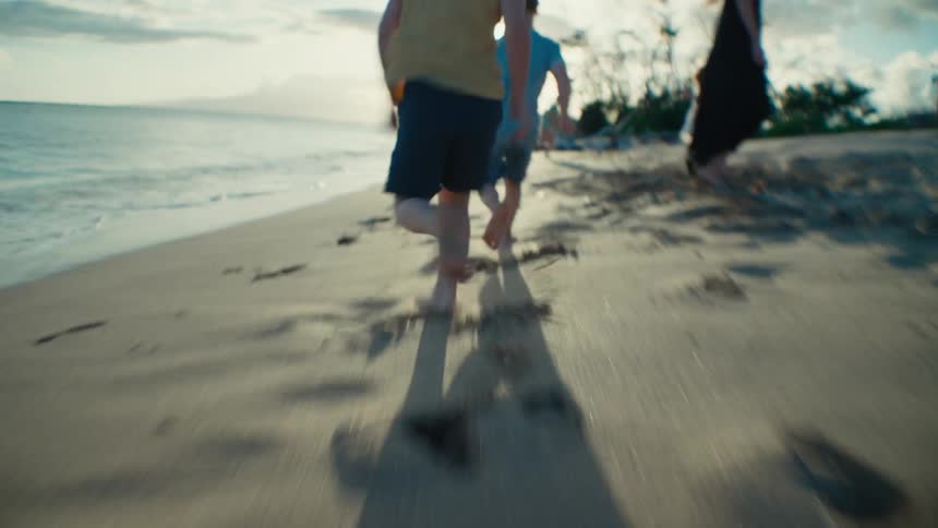 Boys chase after each other on the beach