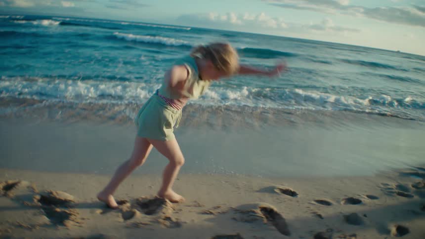 A girl does cartwheels on the beach
