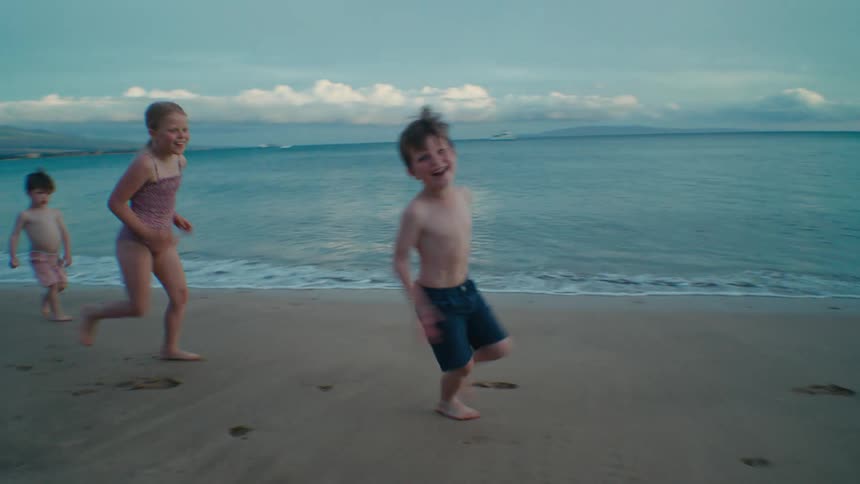 Children chase after each other on the beach