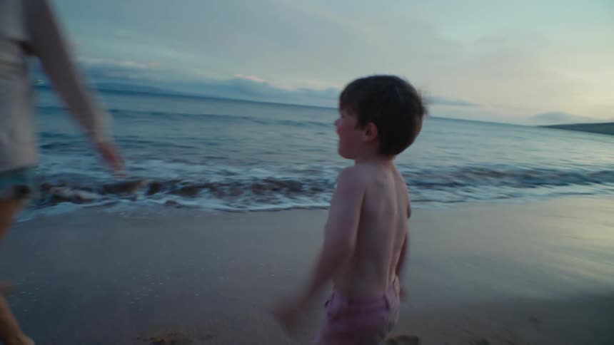 A woman and child run around the beach