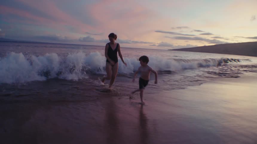 Mother and son run away from waves under a red tinted cloudy sky