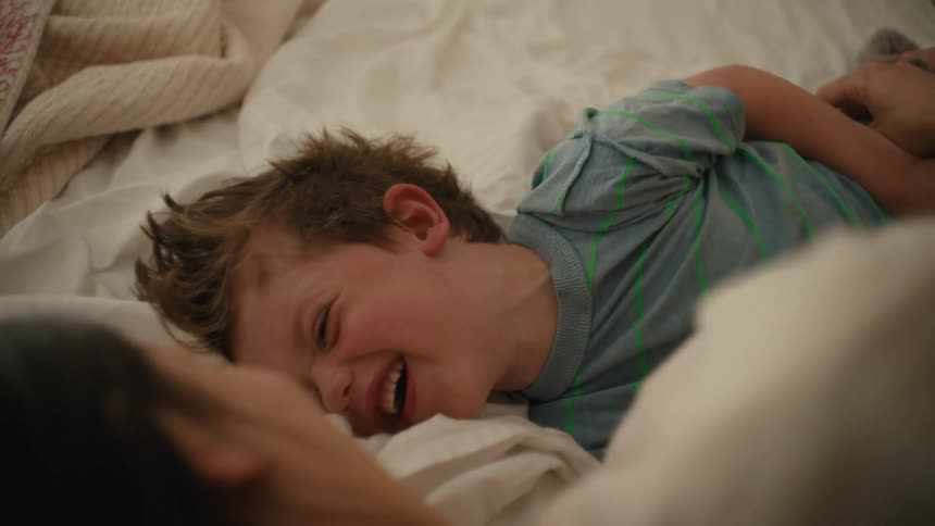 The view is of a portrait of mother and child goofing around in bed