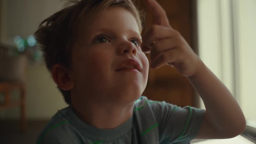 Toddler boy with gray t shirt points his finger