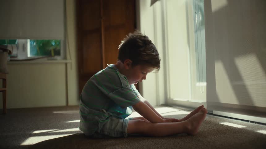 A portrait of a kid sitting on the floor